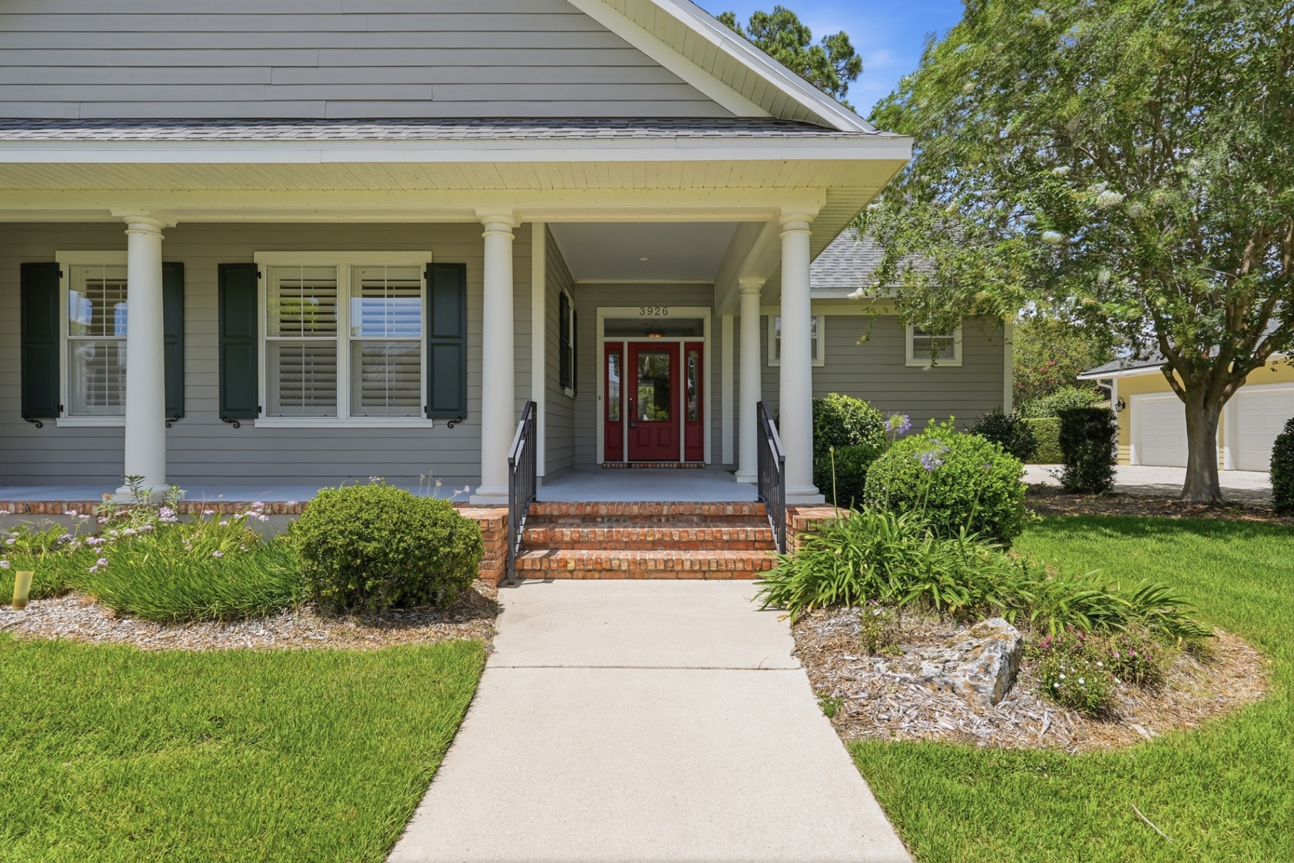 Front porch with classical columns and red double doors
